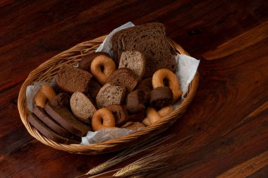 Çavdar ekmeği, keçiboynuzu, buğday, arpa, yulaf, hasır bir sepette. 