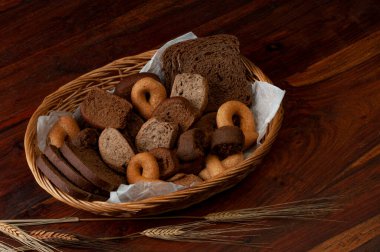 Çavdar ekmeği, keçiboynuzu, buğday, arpa, yulaf, hasır bir sepette. 