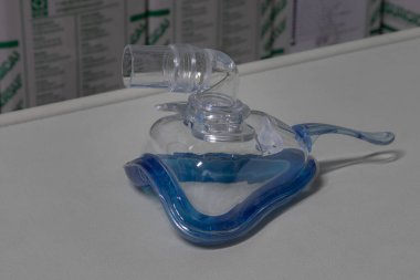 Zararsız havalandırma terapisi için zararsız tam yüz havalandırma maskesi (NIV maskesi) bir enstrüman masasına yerleştirilir. Bu tıbbi ekipman solunum bozukluklarını ve viral zatürreeyi tedavi etmek için kullanılır.