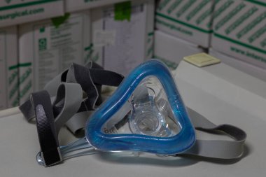 Zararsız havalandırma terapisi için zararsız tam yüz havalandırma maskesi (NIV maskesi) bir enstrüman masasına yerleştirilir. Bu tıbbi ekipman solunum bozukluklarını ve viral zatürreeyi tedavi etmek için kullanılır.