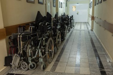 Eski bir hastanenin ya da huzurevinin koridorunda aşınmış mermer zeminde birçok tekerlekli sandalye var. Hall çok esrarengiz ve karanlık. Görünüşe göre eski sahipleri artık aramızda değil..