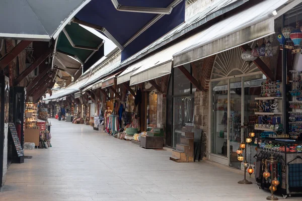 A long curving row at the Turkish tourist market in the heart of Istanbul. The counters are filled with various goods: hookahs, leather items, fabrics, clothes, souvenirs and much more.