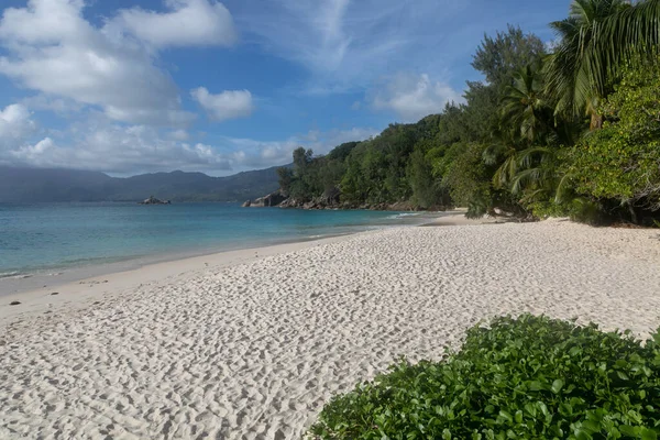 Peaceful seascape of Anse Soleil beach on Mahe island in the Seychelles. Perfect sandy coastline is washed by the turquoise waters of the Indian Ocean. The blue lagoon is guarded with huge rocks