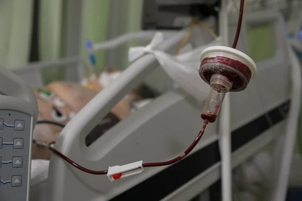 여되고 곳에는 기구들 에둘러 중환자실의 방에서 상태로 환자에게 수혈하는 — 스톡 사진