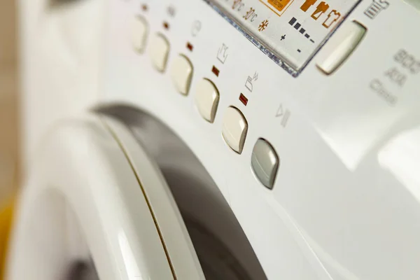 Çamaşırları olan modern bir çamaşır makinesi. Kontrol düğmelerini ve panelini kapat