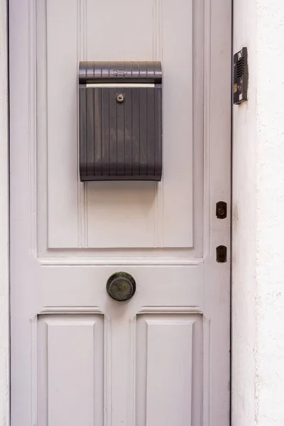 Closed white door with a mailbox