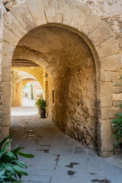 Monells, a beautiful medieval village in the Baix Empord. Gerona. Spain. Arch in the narrow streets of the village.