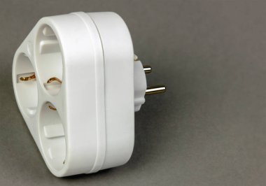 Gri arkaplanlı beyaz üç çatallı soket adaptörü