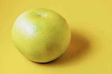 Sarı arka planda greyfurt, yakından gölgelendirilmiş.