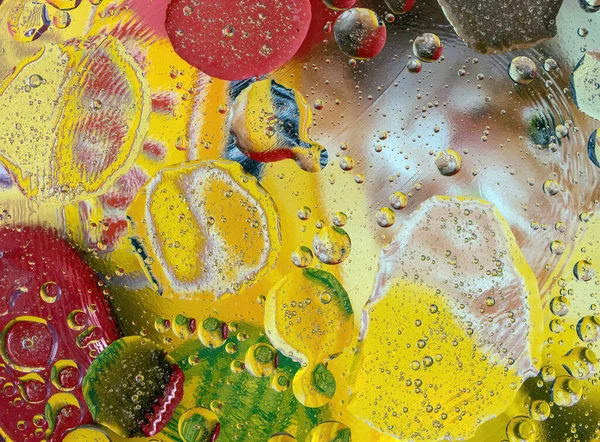 Renkli yağ ve su damlacıklarının arka planında ışık ve renk yansımaları var.