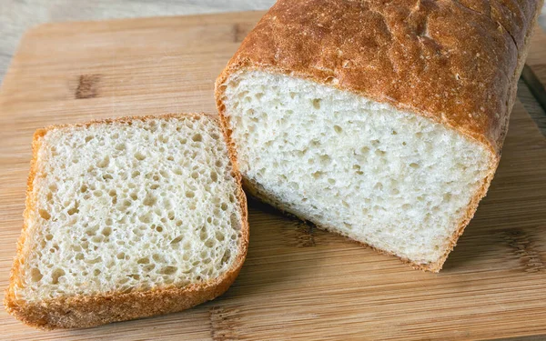 Κόβουμε Ένα Καρβέλι Άσπρο Ψωμί Μια Φέτα Ένα Ξύλο Κοπής — Φωτογραφία Αρχείου