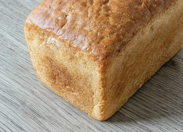Close Van Een Brood Het Oppervlak Van Een Eiken Tafel — Stockfoto