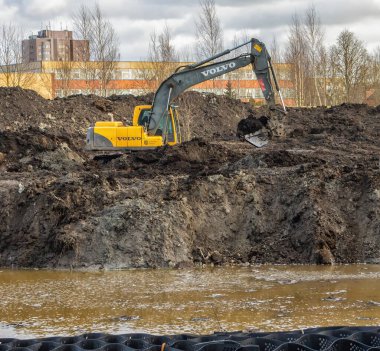 Şehrin kenar mahallelerinde, güçlü bir kazıcı VOLVO 'nun gölet kazdığı bir park hazırlanıyor. Panevezys, Litvanya 10 Şubat 2022