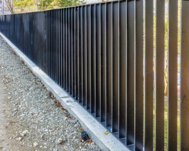 Şehir parkındaki metal çitler, dik bir yamaçtan korunma.