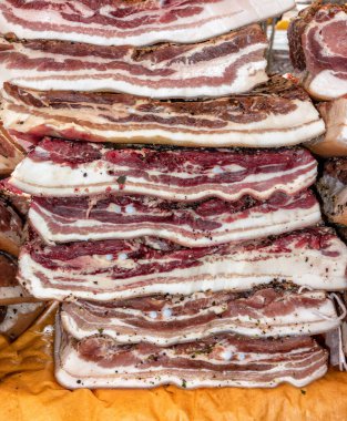 Bir demet soğuk füme domuz pastırması ve açık hava tezgahında baharatlar.