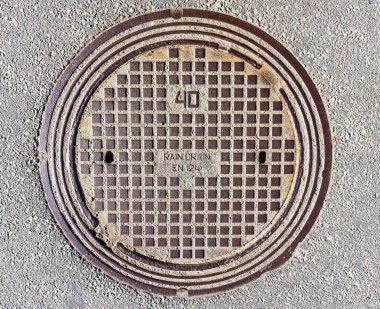 Asfalt kaldırımda kanalizasyon kapağı, üst manzara. Panevezys, Litvanya 23 Mart 2022