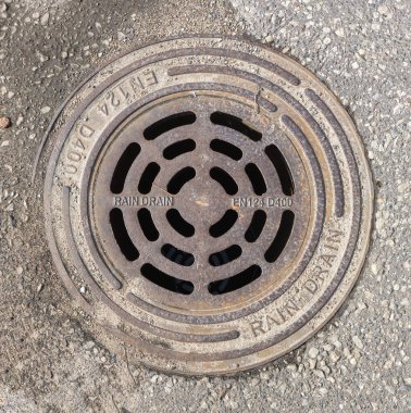 Yuvarlak yağmur kanalizasyon kapağı - asfalt kapağındaki ızgaranın üst görüntüsü. Panevezys, Litvanya 16 Nisan 2022