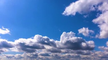 Zaman soldan sağa doğru mavi gökyüzünde beyaz bulutların hızlı hareketini hızlandırır.