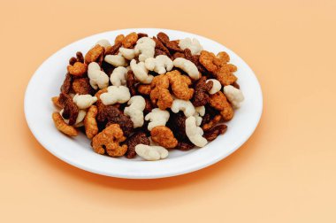 Fil heykelciği, kakao, karamel ve hindistan cevizi olan çocuklar için turuncu arka planda beyaz bir tabakta kuru kahvaltı.