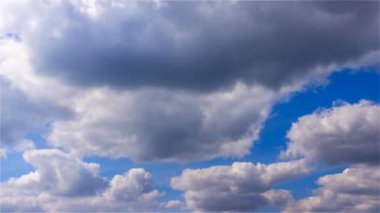Güneşli bir günde mavi gökyüzünde rüzgarda esen büyük beyaz balon bulutları şekil değiştiriyor, zamanı hızlandırıyor.