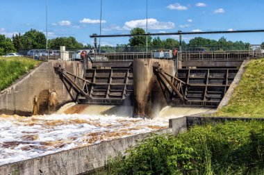 Şiddetli yağmurdan sonraki yaz köpük ve dalgalarla akan nehir suyu güneşli bir günde barajdan görünür.