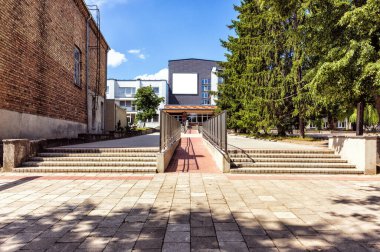 Yaz mevsiminde güneş ışığı merdivenlerinde boş bir reklamı ve engelli girişi olan bir binaya.