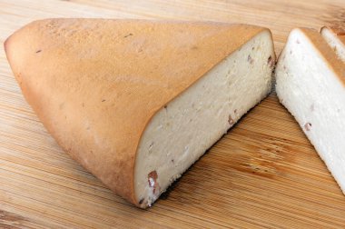 smoked cottage cheese with slices of ham on a bamboo cutting board