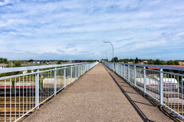 raised high pedestrian bridge with railings over the railway with a panorama. Panevezys. Lithuania. 07. 27. 2022.