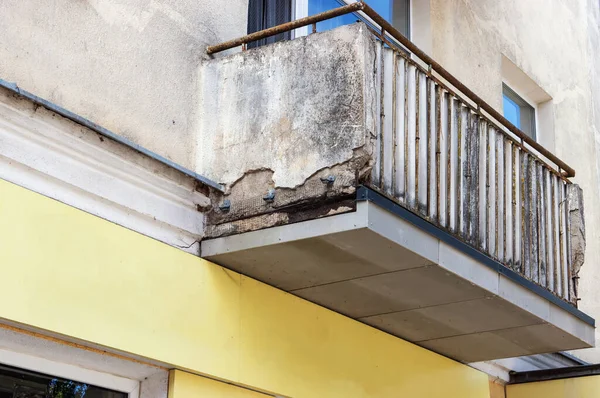 Bir apartmanın ön cephesinde eski bir balkona yakın çekim.