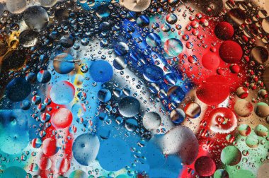 Su yüzeyindeki çeşitli şekillerdeki yağ kabarcıklarının soyut renkli arkaplanı