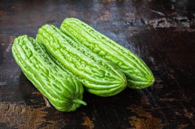 Fresh bitter gourd on a wooden background