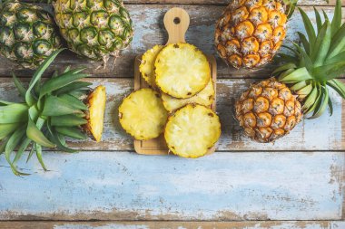 Fresh pineapple fruit sliced on  wooden cutting board