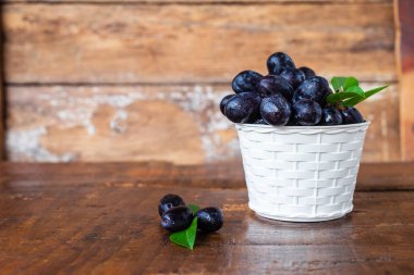 Black grapes in a basket on a wooden table