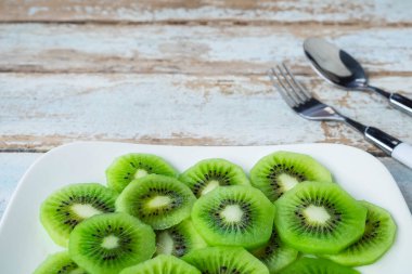 Fresh kiwi fruit in a plate on a wooden table