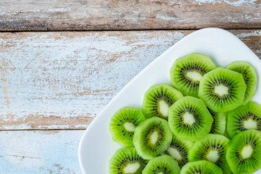 Fresh kiwi fruit in a plate on a wooden table