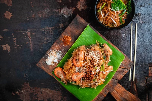 Tayland yemeği, Tayland usulü kızarmış erişte, karides ve sebzeli Pad Thai, ahşap masa.