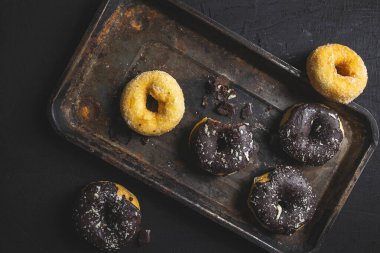 Colorful donuts on Black table. Top view