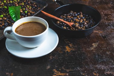 een kopje koffie en koffiebonen op een houten tafel