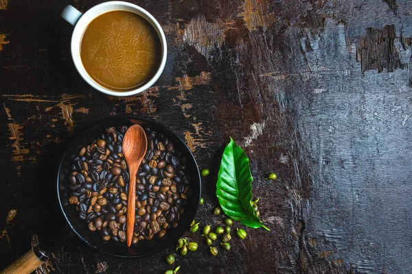 een kopje koffie en koffiebonen op een houten tafel