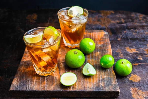 Tahta masada buzlu limon çayı ve limon.