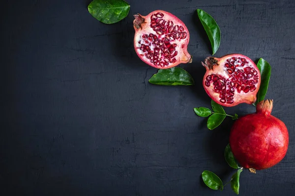 pomegranate fruit sliced on a black background