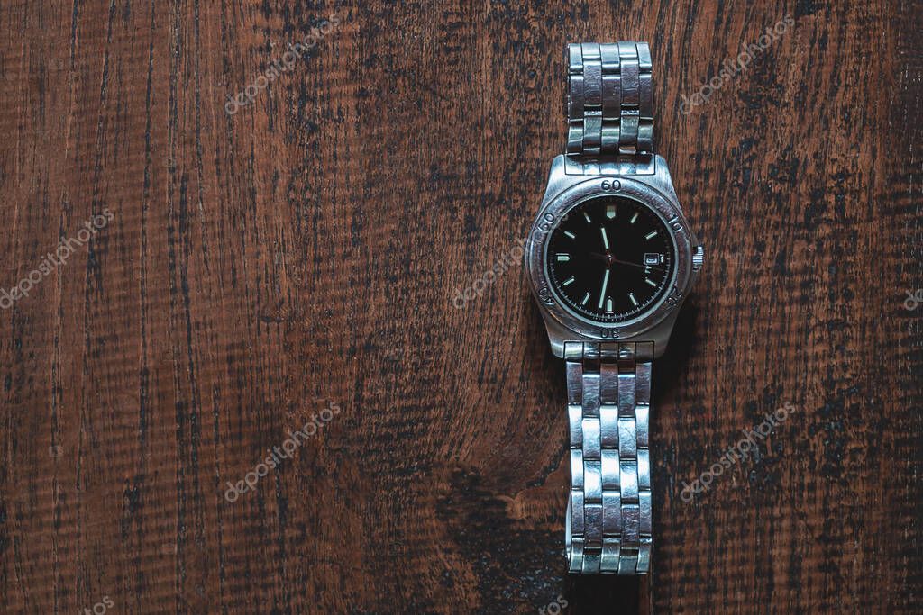 Stainless steel watch on wooden background