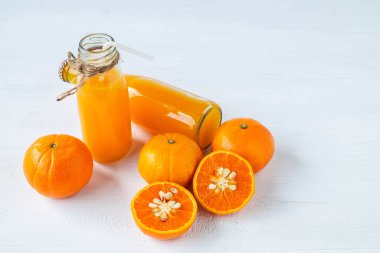 Taze narenciye ve sıkılmış portakal suyu şişeleri.