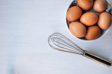 Beyaz ahşap bir masada pişirmek için taze yumurtalar.