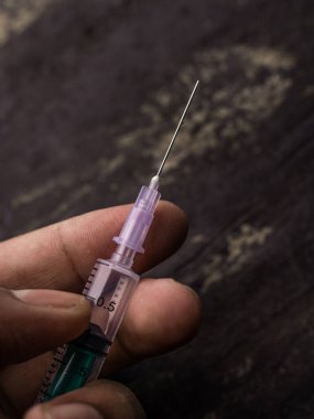 Steroidin yan etkileri şırınga ve insan eli ile desenli arkaplan görüntüsü üzerinde.