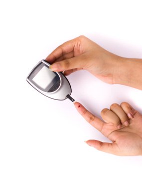 Kan şekeri ölçer, kan şekeri değeri beyaz arka plandaki bir parmakla ölçülür..