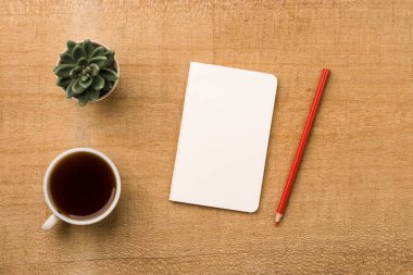 Boş defter ahşap masa, üst görünüm ve düz yatak için hazır..