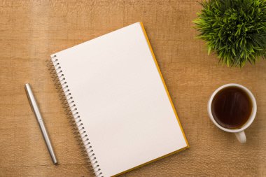 Boş defter ahşap masa, üst görünüm ve düz yatak için hazır..