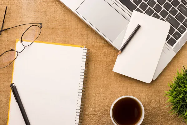 Boş defter ahşap masa, üst görünüm ve düz yatak için hazır..