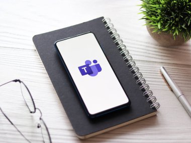 Microsoft takımlarının logosu telefon ekranı stok görüntüsü üzerinde.